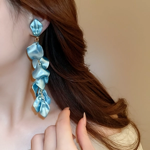 Close-up of elegant blue rose petal tassel earrings on a model with metallic finish