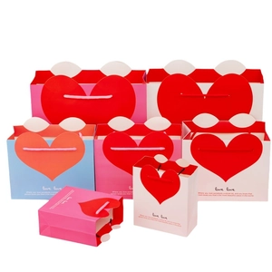 Festive paper gift bags with red heart patterns and rope handles for special occasions