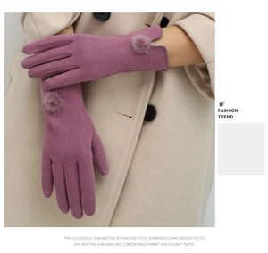 Detail of warm winter glove with elegant fur ball accent and V-shaped notched cuff