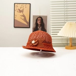 Caramel crochet straw sun hat with floral pearl detail in an elegant indoor setting