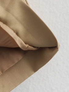 Detailed macro view of khaki twill fabric texture and smooth lining on short trench coat