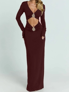 Detail of deep V-neckline and diamond-encrusted hardware on a long-sleeve maxi dress