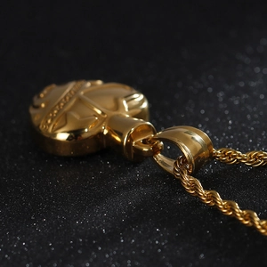 Close-up of a gold-toned heart-shaped engraved pendant with a stylish twisted rope chain