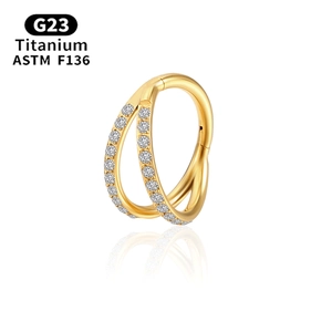 Detailed macro of a gold G23 titanium double hoop ring set with small cubic zirconia