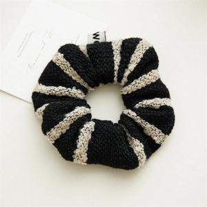 Close-up of a French vintage striped tweed hair scrunchie with knitted texture