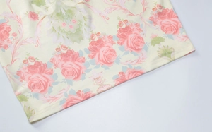 Détail d'une robe fleurie ajustée avec motifs de roses roses et texture du bord