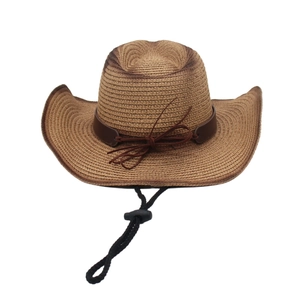 Dettaglio cappello da cowboy in paglia intrecciata con fascia in cuoio e laccio regolabile