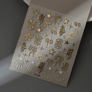 Macro view of 3D embossed nail art stickers with gold bows and white flower patterns