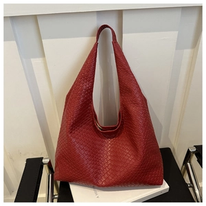 Red woven leather tote bag with large capacity displayed in a modern home setting