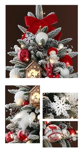Detailed view of mini Christmas tree with artificial snow, red bows and warm LED lights