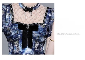 Detail of blue floral silk dress featuring black velvet bow and lace stitching