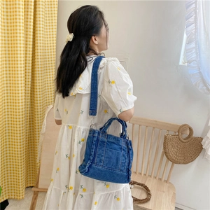 Detailed view of the adjustable strap and denim texture on the blue vintage shoulder bag