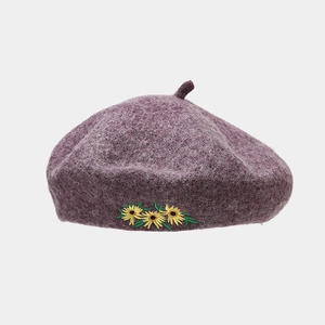Detailaufnahme der lila Wollbaske mit detaillierter gelber Sonnenblumen-Stickerei