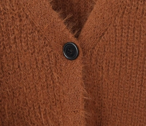 Macro detail of brown mohair cardigan featuring fuzzy knit texture and black button