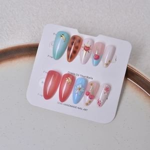 Macro shot of 3D cherry almond press-on nails with floral and leopard art on display card