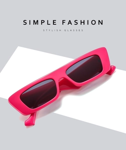 Detail of hot pink rectangular sunglasses with sleek high-gloss finish and dark lenses