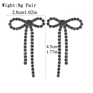 Macro detail of black rhinestone bow tassel earrings with dimensions of 4.5cm length