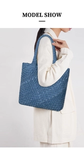 Side view of a blue denim woven tote bag on model showing large capacity and stylish shape