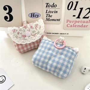 Detailed view of quilted cotton earphone pouches with floral patterns and pink clips