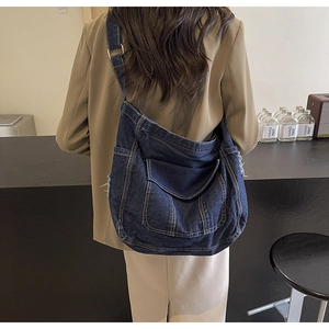 Détails du cabas en jean bleu foncé avec franges effilochées et boucle en métal réglable