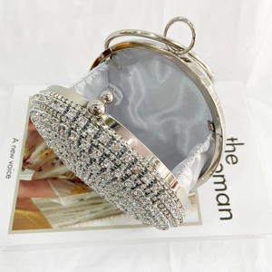 Macro shot of rhinestone evening bag interior with silver metal handle and satin lining