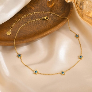 Detailed macro view of gold-plated stainless steel star evil eye necklace on silk