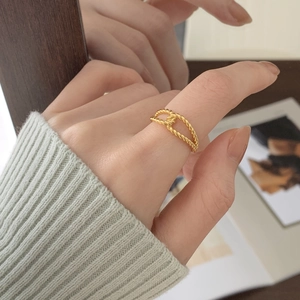 Detailed view of gold twisted double-layer rope ring on finger for a minimalist look
