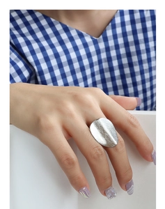 Detailed view of an oversized irregular oval ring with a brushed silver matte finish