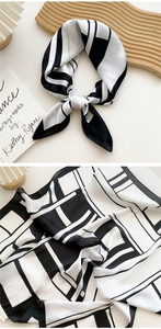 Detail of silk scarf with black and white geometric patterns and smooth satin texture