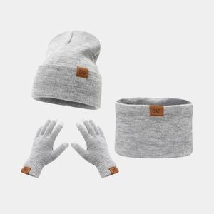 Detail view of the gray knitted set showing DAD leather labels on the hat, scarf, and gloves