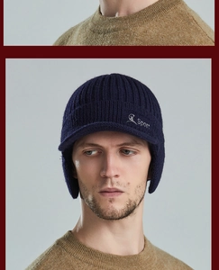 Detail of navy knit winter hat with earflaps and sport embroidery on a model