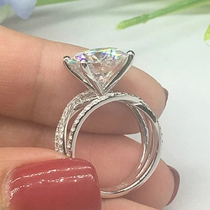 Detailed macro view of silver 925 classic four-claw zircon ring on a finger