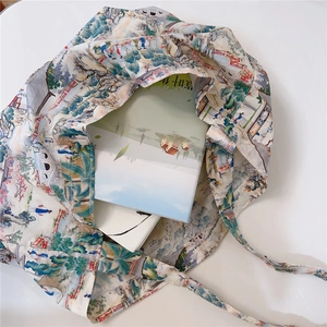 Detail of artistic cotton tote bag with traditional Chinese landscape print and inner books