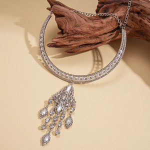 Close-up of multilayer silver fringe choker with white pearls and rhinestones on wood