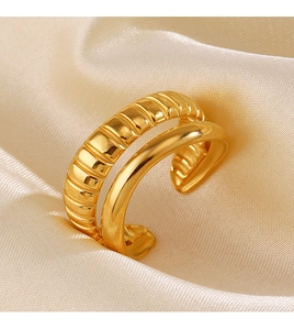 Macro detail of gold layered open ring with polished and ripple textures on silk