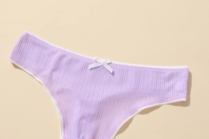 Detail of purple ribbed polyester thong with white trim and a cute decorative bow