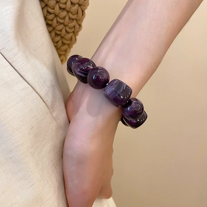 Détail d'un bracelet en perles acryliques violet marbré avec perles irrégulières
