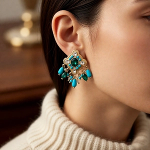 Vintage style drop earrings with green rhinestones and turquoise beads on model