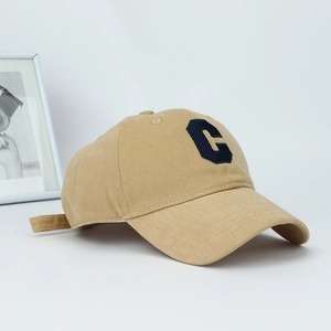 Close-up of khaki cotton baseball cap featuring blue letter C patch and twill texture