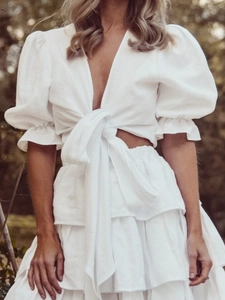 White two-piece set featuring puff sleeve tie-front crop top and tiered ruffle maxi skirt