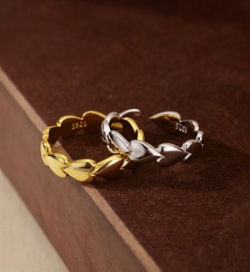 Macro shot of gold and silver S925 sterling silver heart rings with detailed engraving