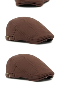 Macro detail of the brown knitted cotton beret showing metal buckle and texture
