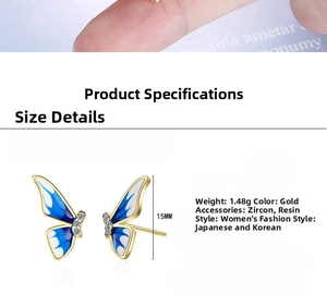 Detail view of enamel butterfly earrings with blue gradient wings and zircon inlays