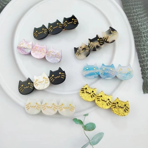 Three-head acetate cat hair clips in various marble patterns and colors on a white plate
