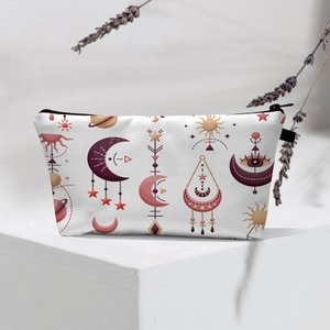 Detailed view of evil eye makeup bag with moon and sun patterns on white display