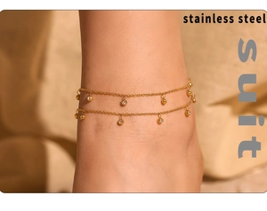 Detail of a double-layered gold stainless steel anklet with small zircon charms on foot