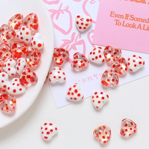 Close-up of red polka dot heart-shaped beads on a decorative plate for DIY crafts