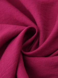 Macro detail of the elegant berry red woven fabric texture and premium linen fiber finish