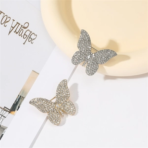 Macro shot of silver and gold butterfly brooches with shimmering crystal rhinestones