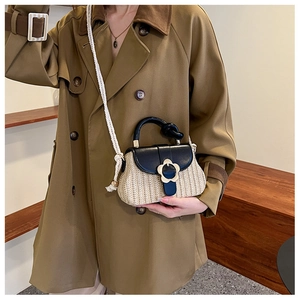Détail du sac en paille avec boucle fleurie en métal et bandoulière en corde blanche